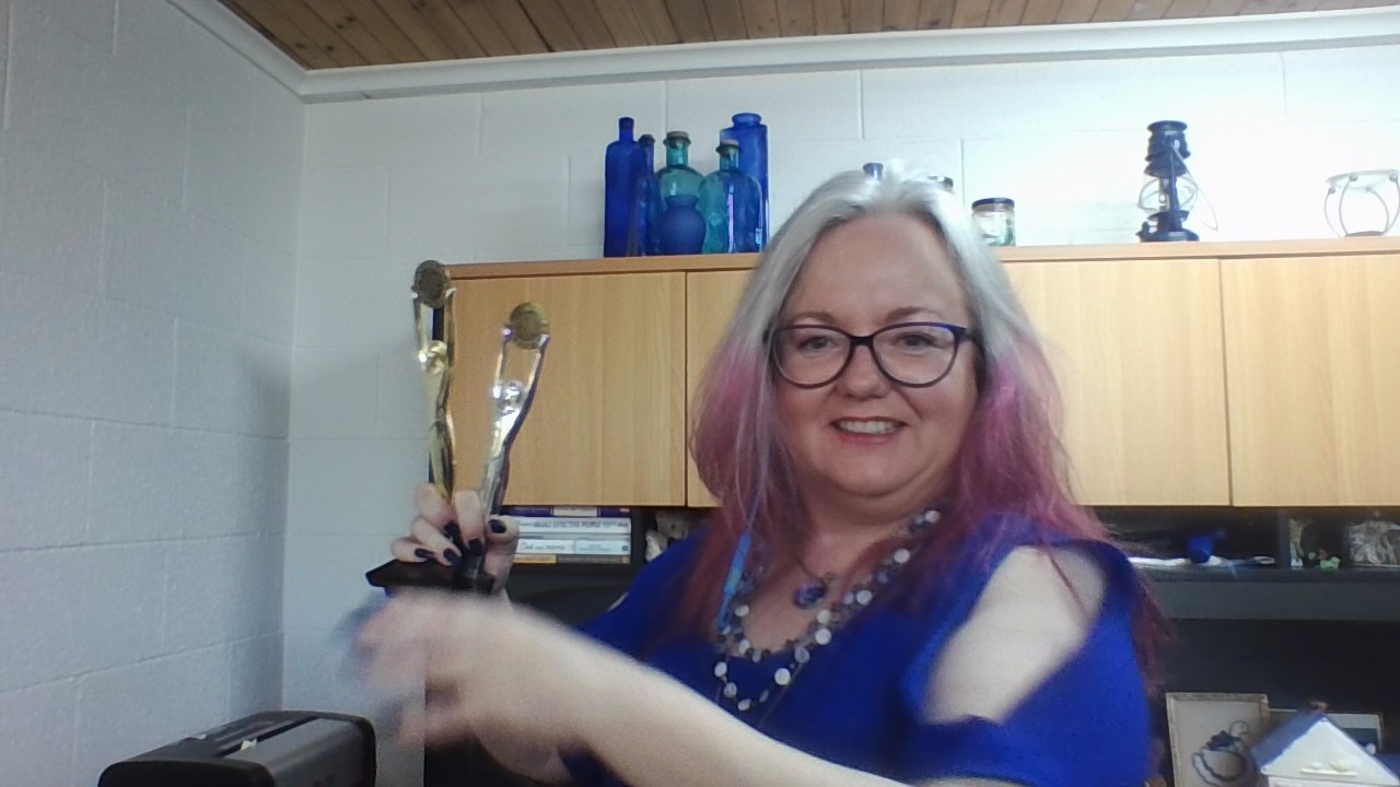 Suzy Molloy is holding up her gold and her silver sales trophies